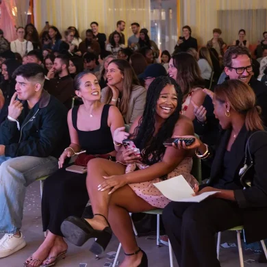 Audience members laughing and reacting during Anna DeGuzman's magic show