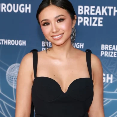 Anna DeGuzman in a black gown at the Breakthrough Prize ceremony step-and-repeat backdrop